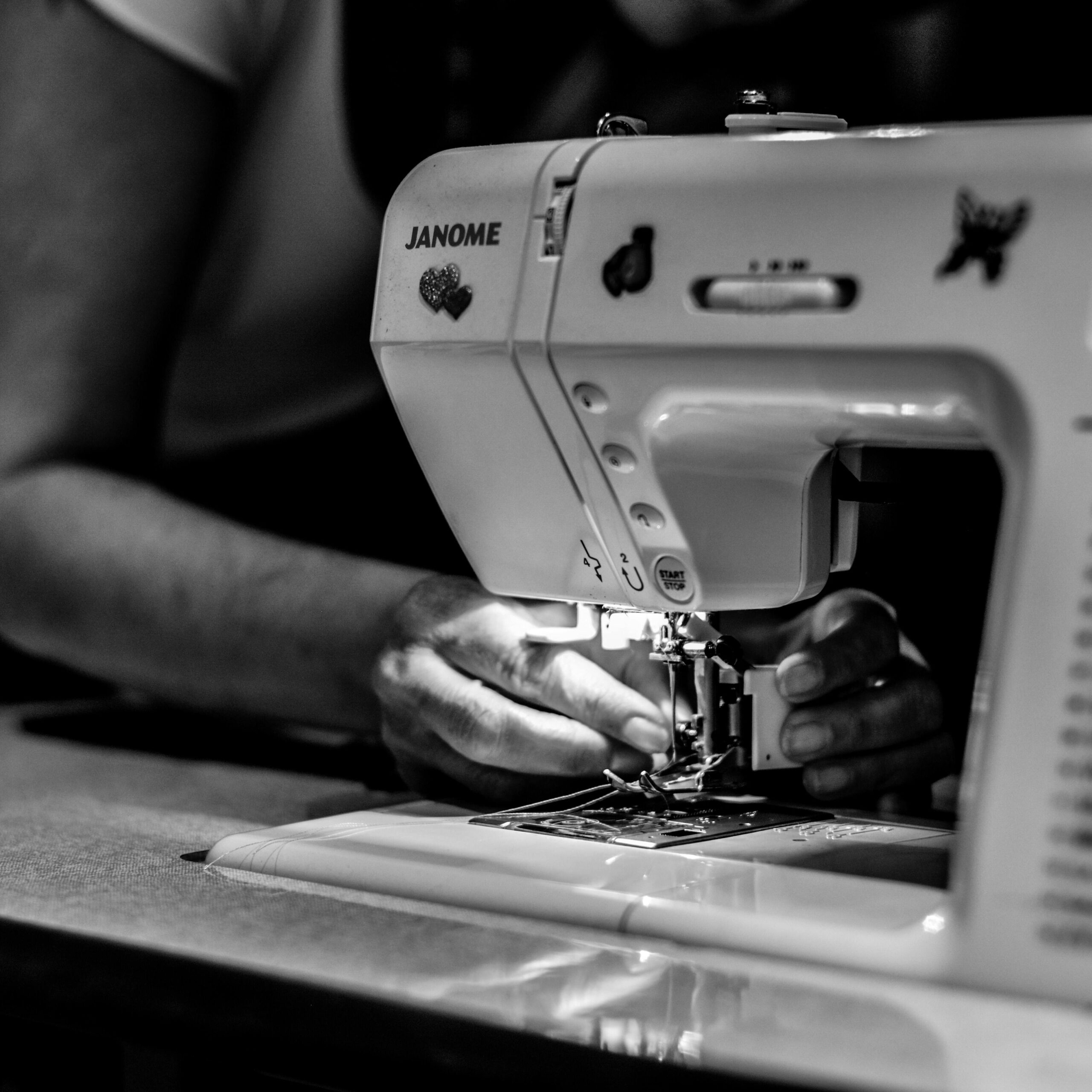 pexels-photo-2249290-2249290 Detailed black and white photo of hands operating a sewing machine, showcasing craftsmanship.
