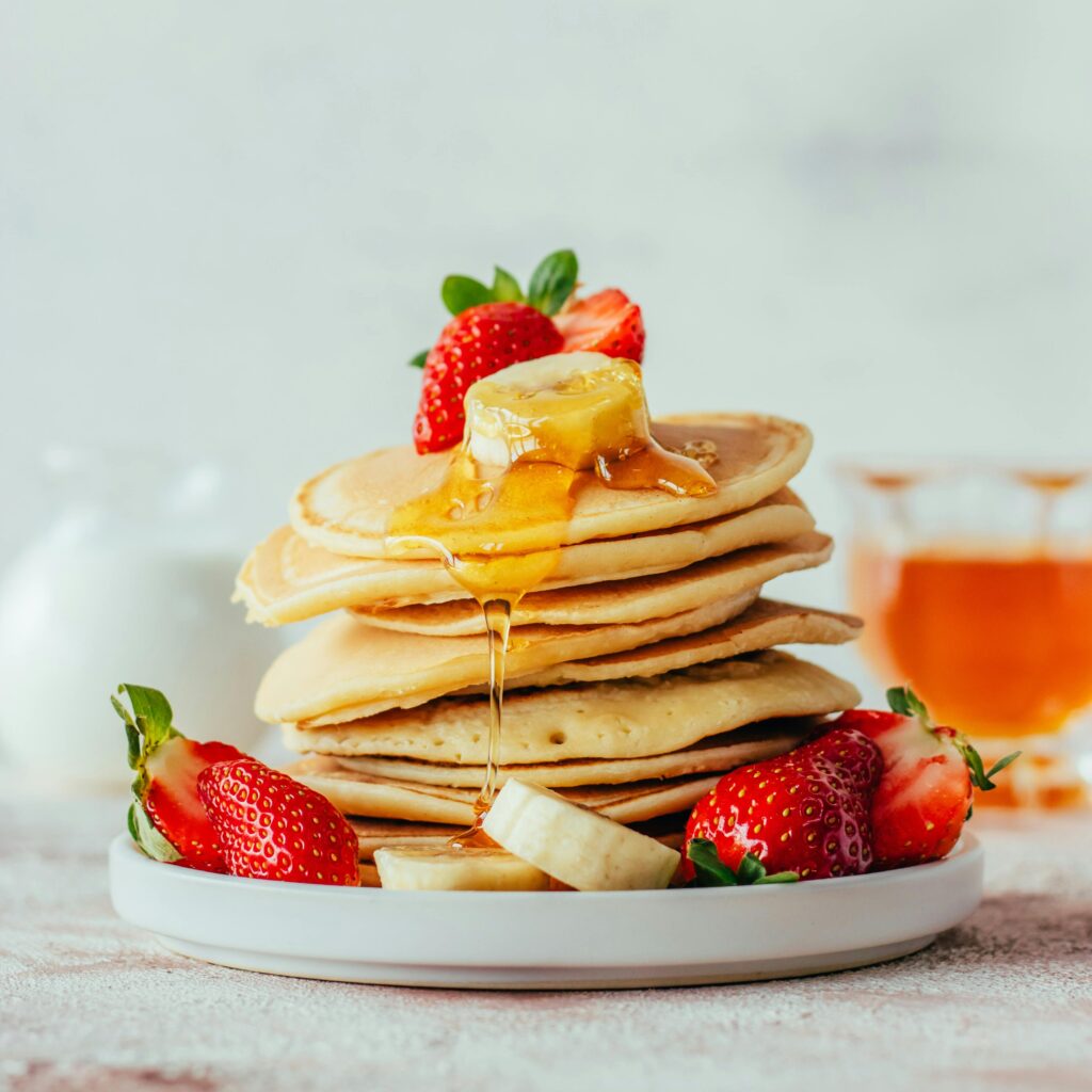 pexels-photo-30892984-30892984 Mouth-watering stack of pancakes topped with strawberries, bananas, and honey. Perfect breakfast dish.