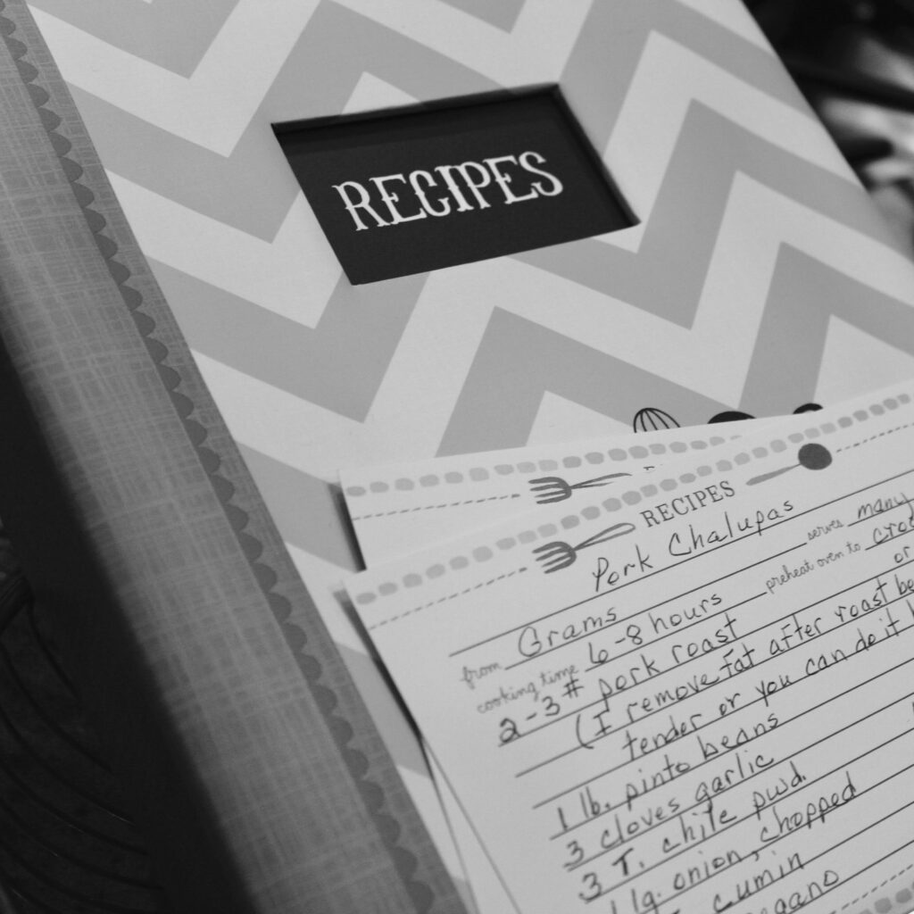 pexels-photo-833109-833109 Monochrome image of a recipe book and handwritten notes in a kitchen setting.